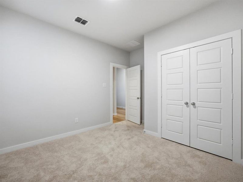Unfurnished bedroom with light colored carpet and a closet