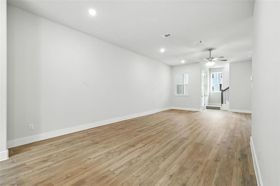 Unfurnished room with recessed lighting, light wood-style floors, a ceiling fan, and stairs