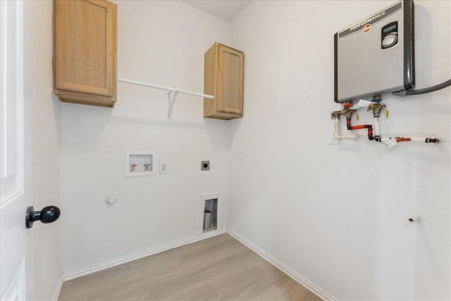 Laundry room with washer hookup, light wood finished floors, cabinet space, gas dryer hookup, and baseboards