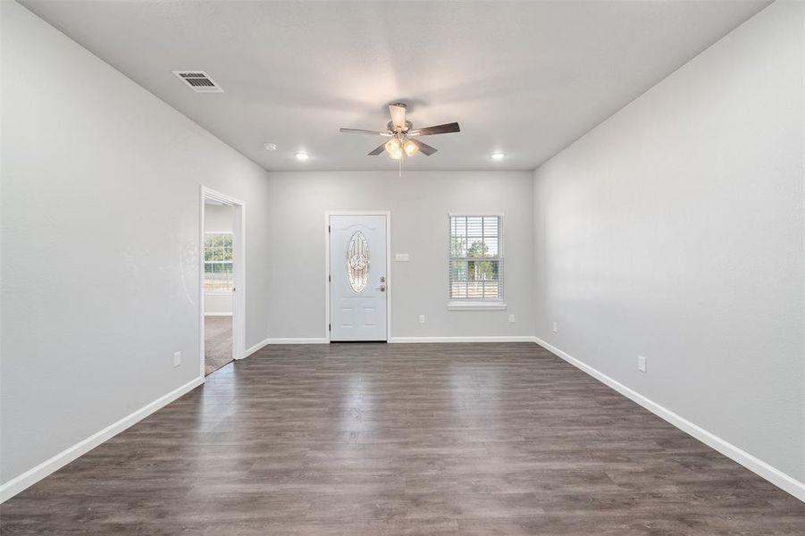 Entrance foyer featuring a healthy amount of sunlight, ceiling fan, and dark hardwood / wood-style flooring