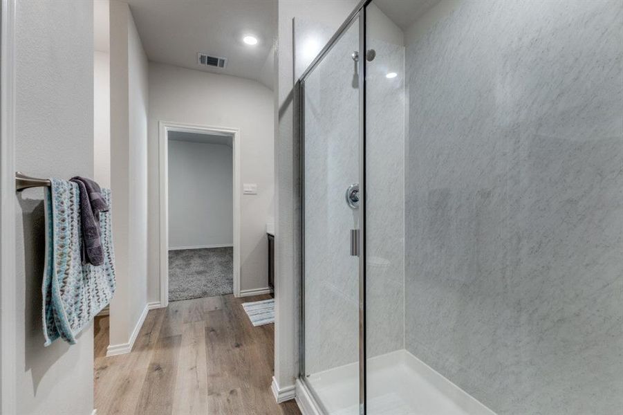 Bathroom with a shower stall, light wood-style floors, vanity, and recessed lighting Bathroom with a shower stall, light wood-style floors, vanity, and recessed lighting