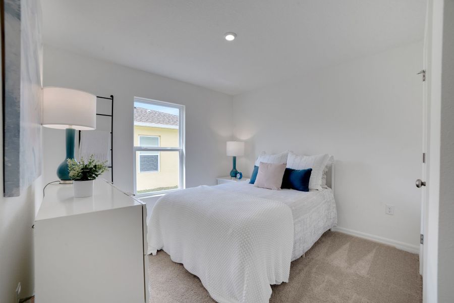 A bedroom with a bed and a lamp.