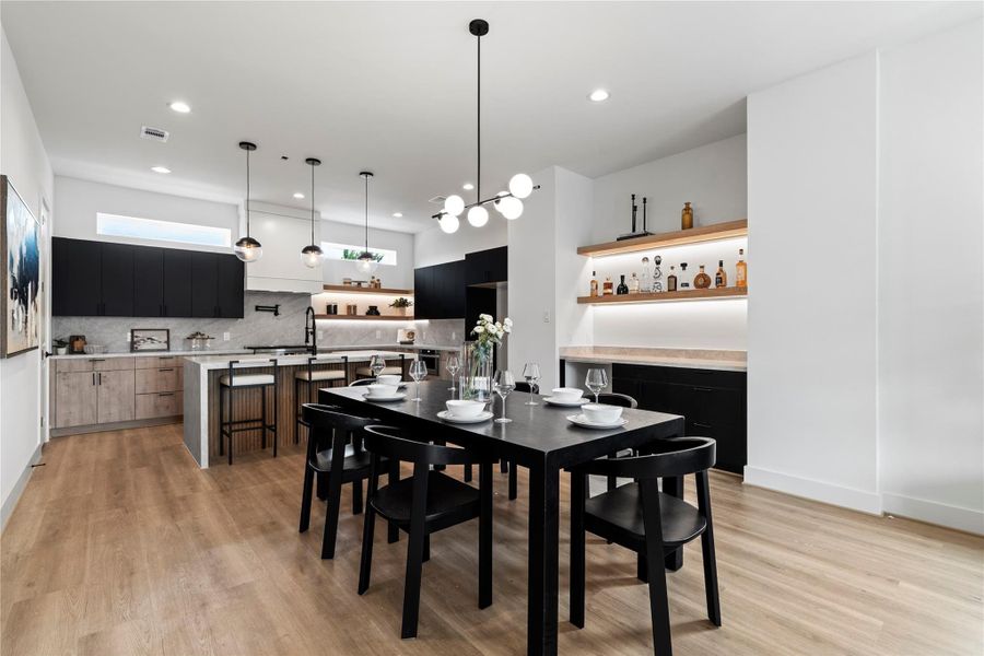 The dining room offers a clean, modern look with views into the kitchen, featuring stylish two-tone European cabinetry. The dining room offers a clean, modern look with views into the kitchen, featuring stylish two-tone European cabinetry.