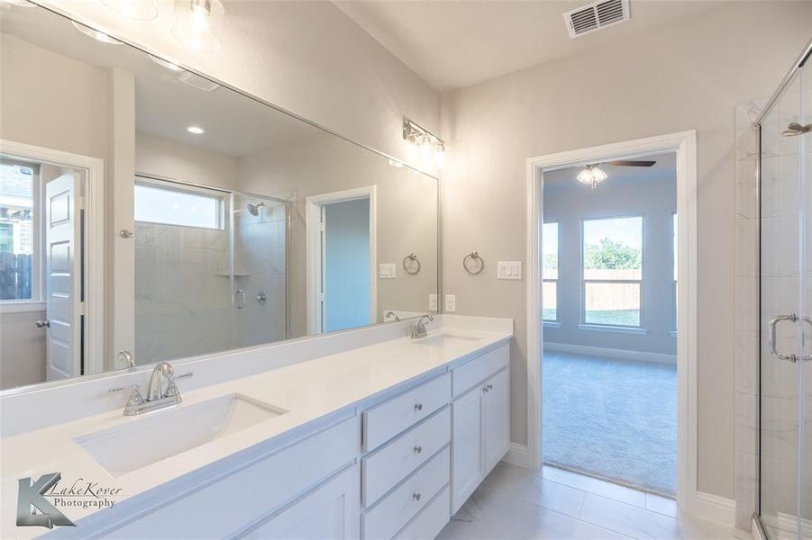 Bathroom featuring a marble finish shower and recessed lighting