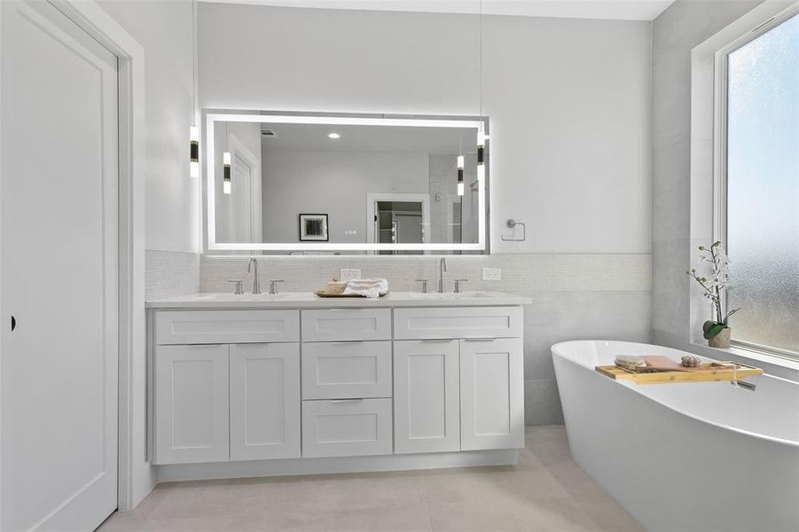 Bathroom with tile patterned floors, a bathtub, and vanity