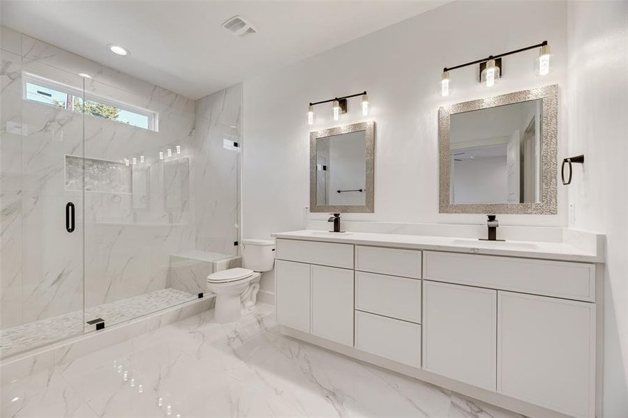 Full bath with a marble finish shower, double vanity, light marble finish floors, and recessed lighting Full bath with a marble finish shower, double vanity, light marble finish floors, and recessed lighting