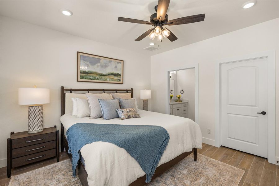 A tranquil bedroom retreat features a ceiling fan, recessed lighting, and a private en-suite bathroom.