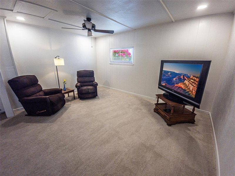 Sitting room with a ceiling fan, carpet flooring, recessed lighting, and wood walls Sitting room with a ceiling fan, carpet flooring, recessed lighting, and wood walls