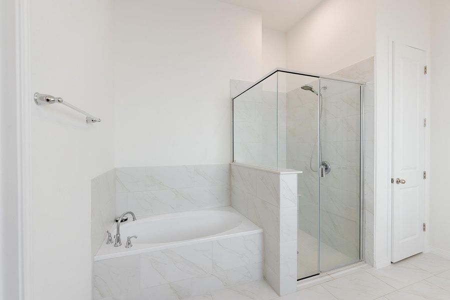 Bathroom featuring a marble finish shower and a garden tub