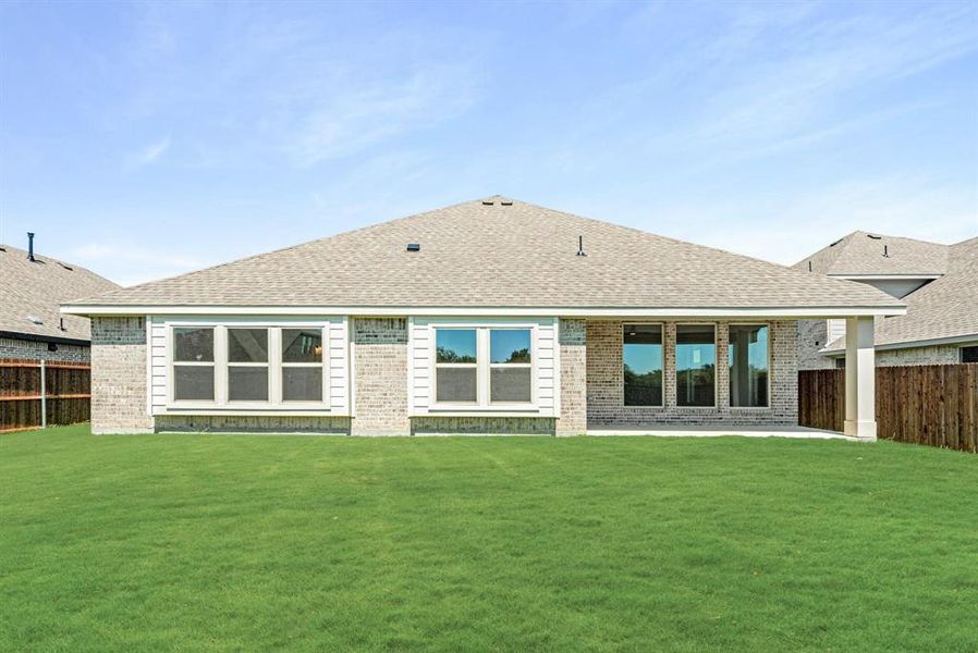 Expansive green lawn with a full brick exterior and covered patio Expansive green lawn with a full brick exterior and covered patio