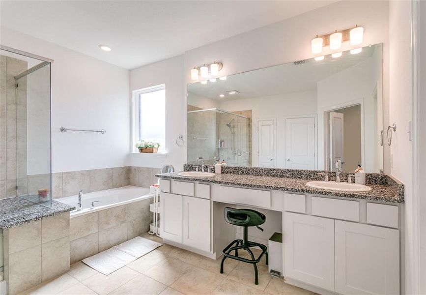 Bathroom with a stall shower, a garden tub, double vanity, and light tile patterned flooring