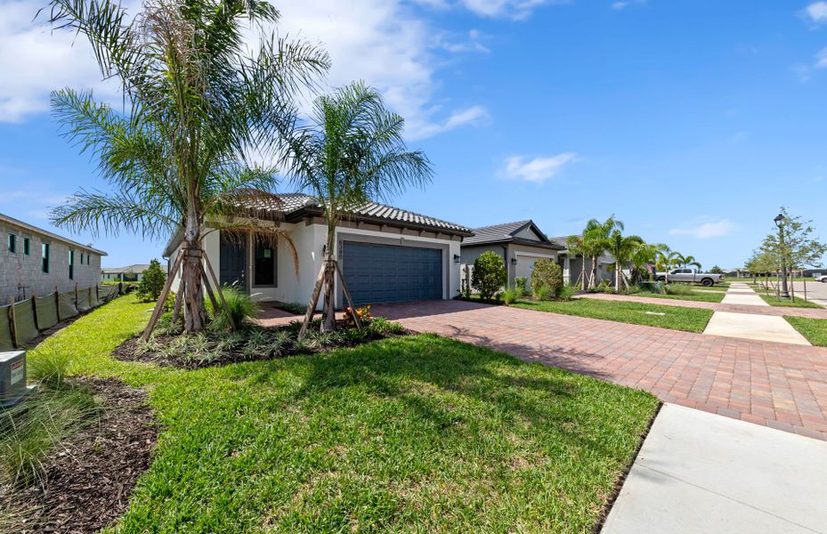 Front exterior of a new home in Del Webb Naples, Ave Maria, FL, highlighting curb appeal (Image 17). Front exterior of a new home in Del Webb Naples, Ave Maria, FL, highlighting curb appeal (Image 17).