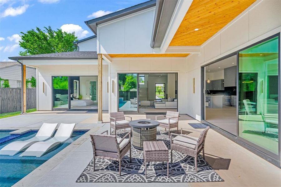 View of patio with an outdoor living space with a fire pit and sink