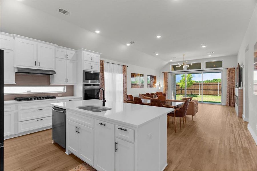 Kitchen featuring appliances with stainless steel finishes, under cabinet range hood, a chandelier, light countertops, and recessed lighting Kitchen featuring appliances with stainless steel finishes, under cabinet range hood, a chandelier, light countertops, and recessed lighting