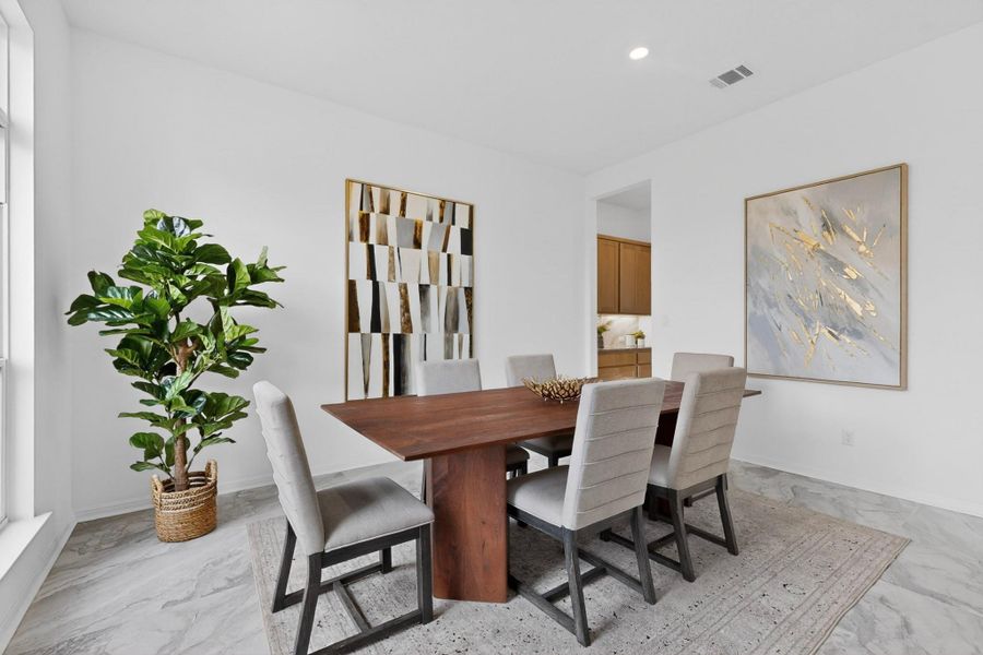 Spacious dining area featuring neutral-toned walls, recessed lighting, and large windows