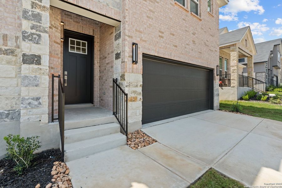 Front exterior of a new home in Hunters Ranch, San Antonio, TX, highlighting curb appeal (Image 24). Front exterior of a new home in Hunters Ranch, San Antonio, TX, highlighting curb appeal (Image 24).