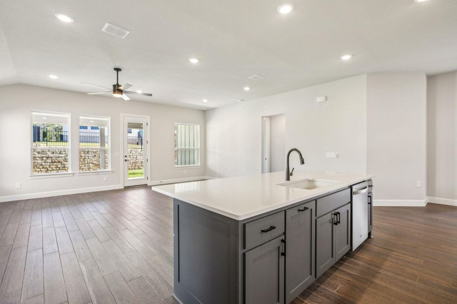 Kitchen with gray cabinets, open floor plan, recessed lighting, a center island with sink, and ceiling fan Kitchen with gray cabinets, open floor plan, recessed lighting, a center island with sink, and ceiling fan