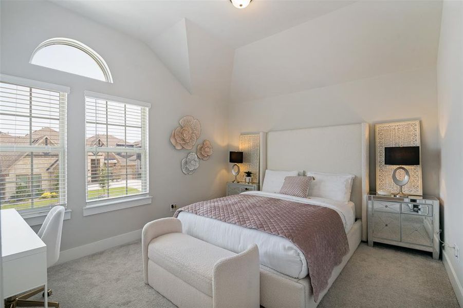 Spacious room featuring vaulted ceilings, a large arched transom window, two double-hung windows with blinds, and soft gray carpeting