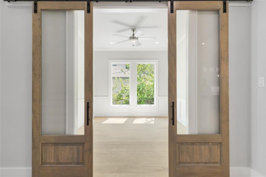 Double glass barn doors open to the Home Office or Formal Dining Room