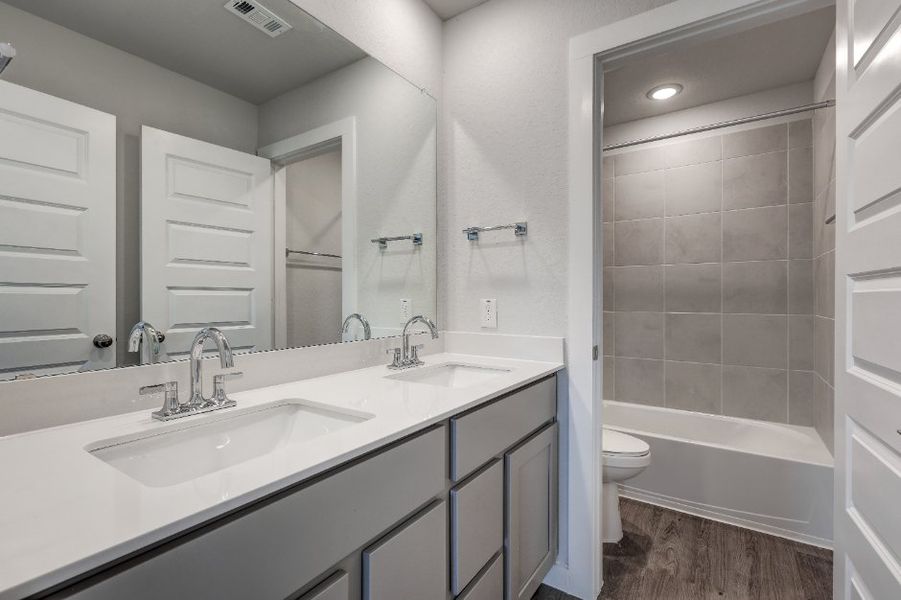 A bathroom with a tub sink and toilet.