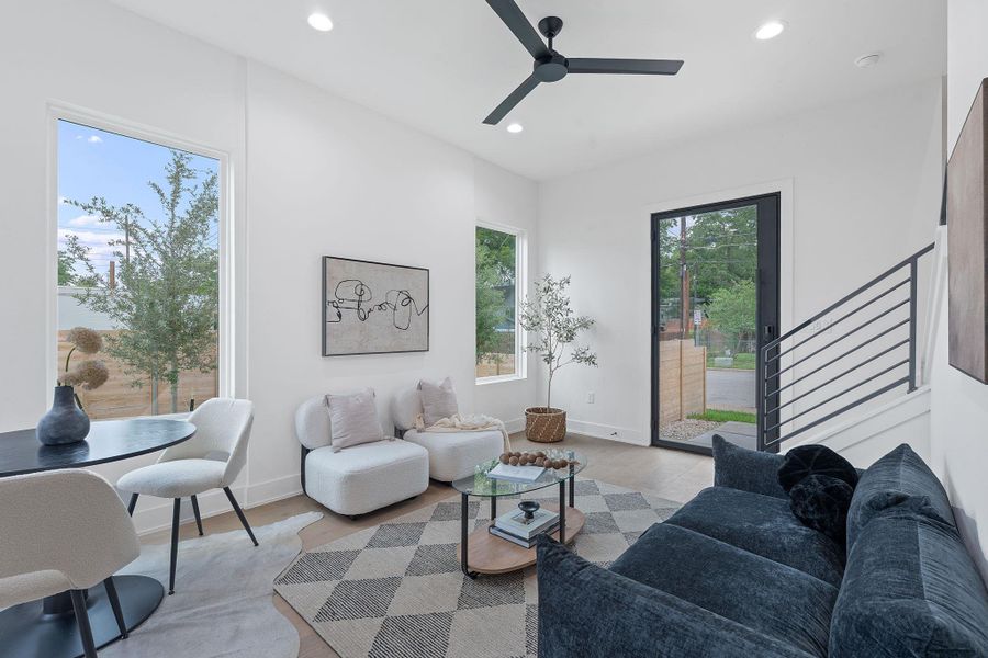 Living area with recessed lighting, ceiling fan, light wood-type flooring, and stairway