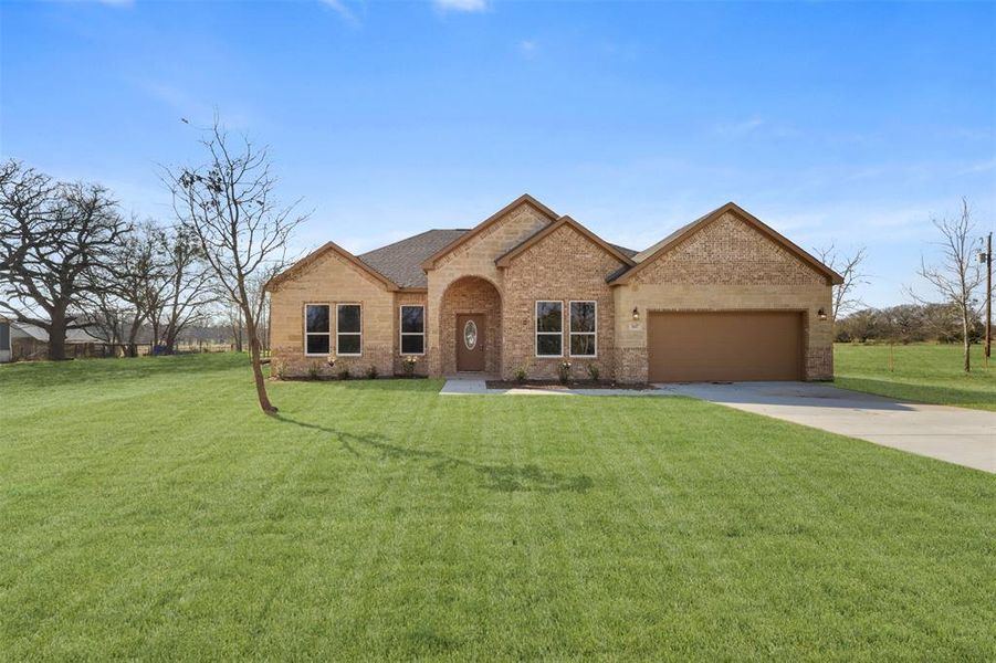 View of front of house with a garage and a front yard