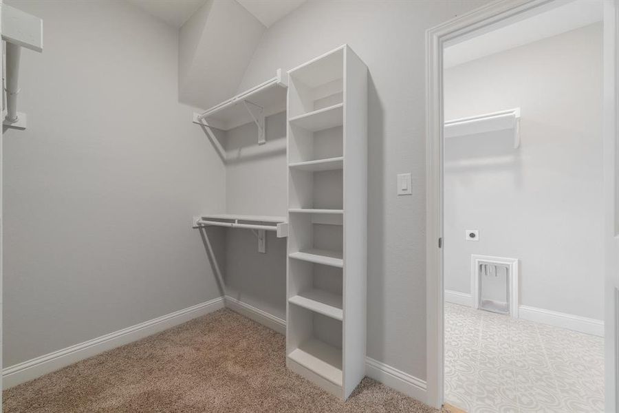 Spacious closet featuring light tile flooring