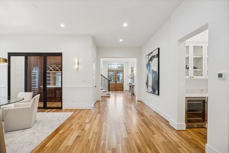 Clear sightlines define the main level, allowing the dining area, wine room, and kitchen support spaces to function independently while staying visually connected. Wide plank white oak floors and recessed lighting guide movement through the home, making entertaining feel effortless and everyday living feel intuitive. Clear sightlines define the main level, allowing the dining area, wine room, and kitchen support spaces to function independently while staying visually connected. Wide plank white oak floors and recessed lighting guide movement through the home, making entertaining feel effortless and everyday living feel intuitive.