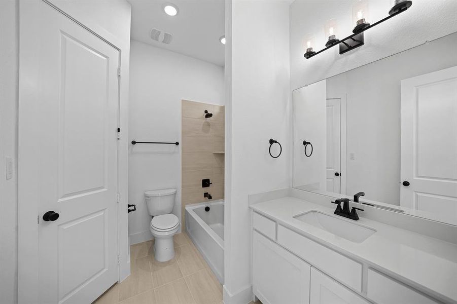 Bathroom featuring shower / bath combination, vanity, light tile patterned floors, and recessed lighting