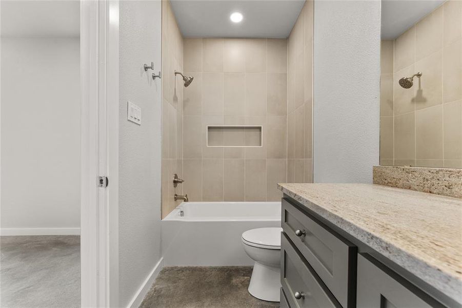 Bathroom with vanity, bathtub / shower combination, and a textured wall Bathroom with vanity, bathtub / shower combination, and a textured wall