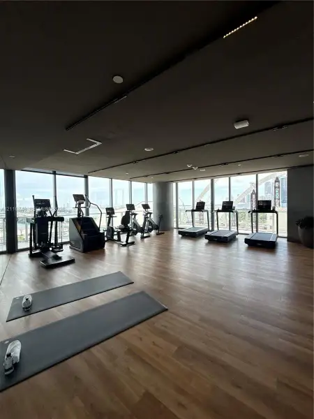 Fitness area featuring floor-to-ceiling windows, wood-finish flooring, and recessed ceiling lighting