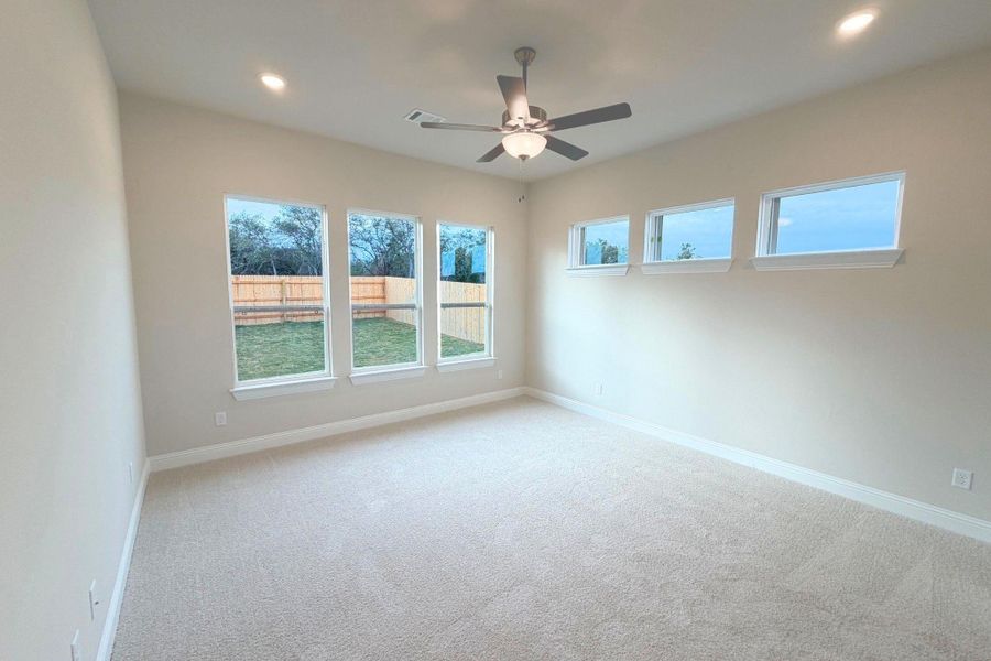 Carpeted empty room featuring plenty of natural light, recessed lighting, and a ceiling fan