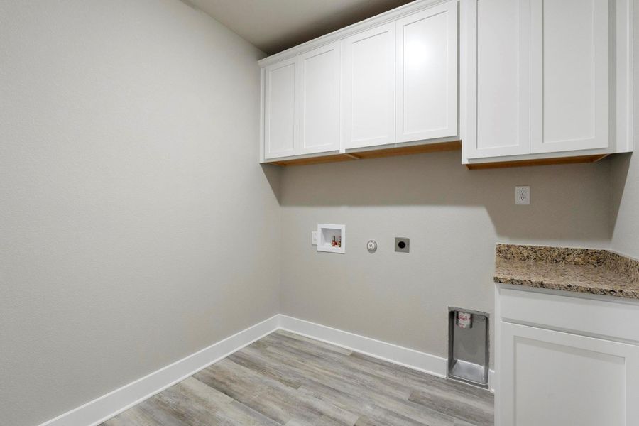 Laundry room with hookup for a gas dryer, light wood-type flooring, washer hookup, hookup for an electric dryer, and cabinet space