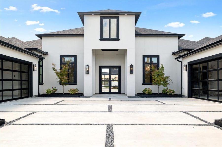 View of front of house featuring roof with shingles, driveway, stucco siding, and a garage