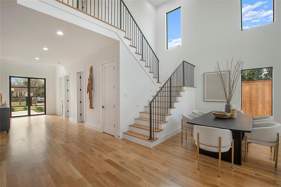 Staircase with wood-type flooring and a towering ceiling