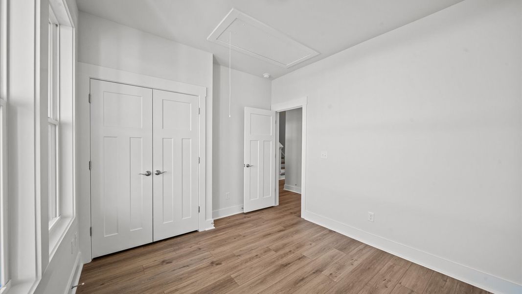 Thoughtfully designed secondary bedrooms featuring hardwood flooring and tasteful detail