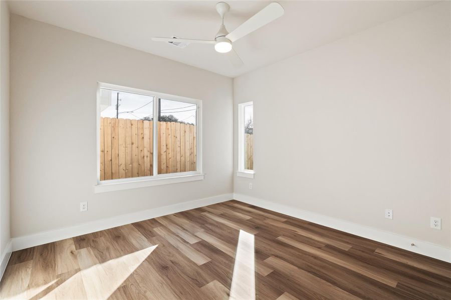 A well-sized second guest bedroom with a side-yard view, ceiling fan, and an easy layout that works as a bedroom, office, or flex space.