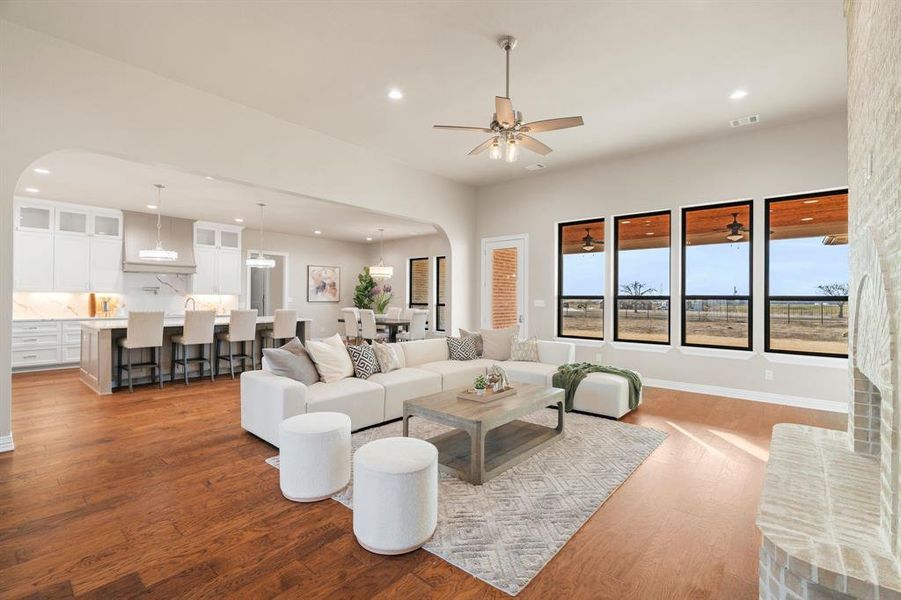 Living room with ceiling fan and hardwood / wood-style flooring