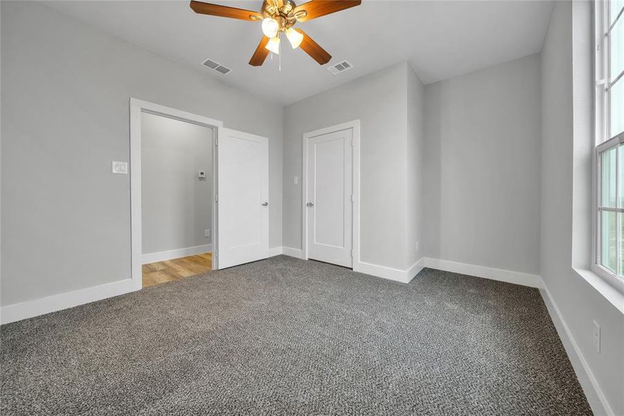 Carpeted spare room featuring ceiling fan