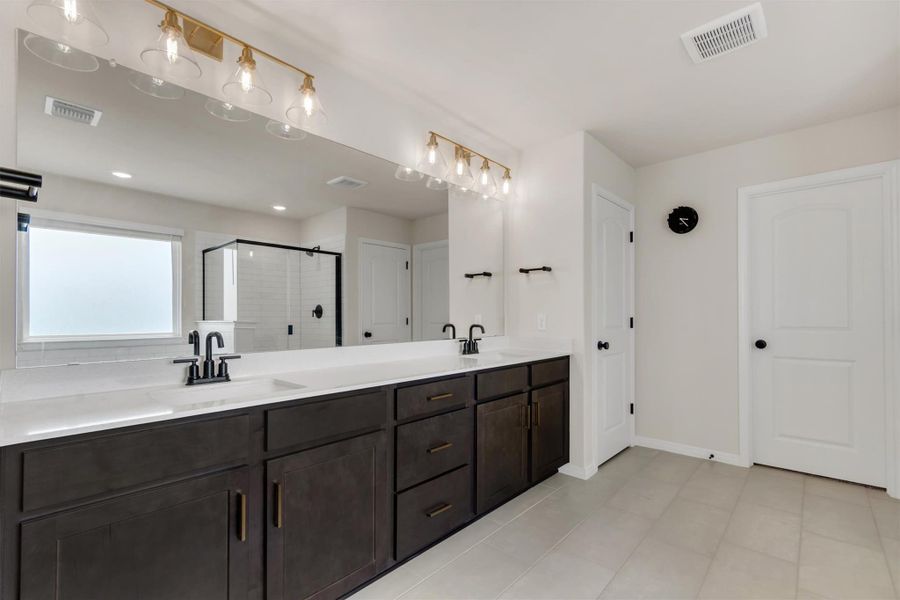 Large vanity with dual sinks offer plenty of storage in this gorgeous primary bathroom Large vanity with dual sinks offer plenty of storage in this gorgeous primary bathroom