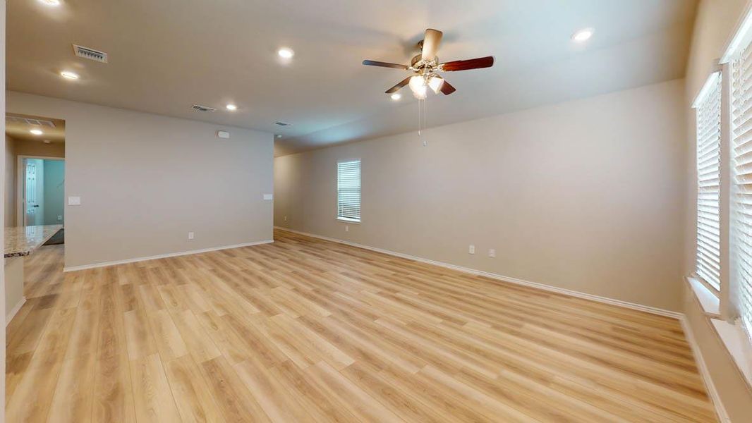 A well-lit living area features warm wood flooring and recessed lighting. A well-lit living area features warm wood flooring and recessed lighting.