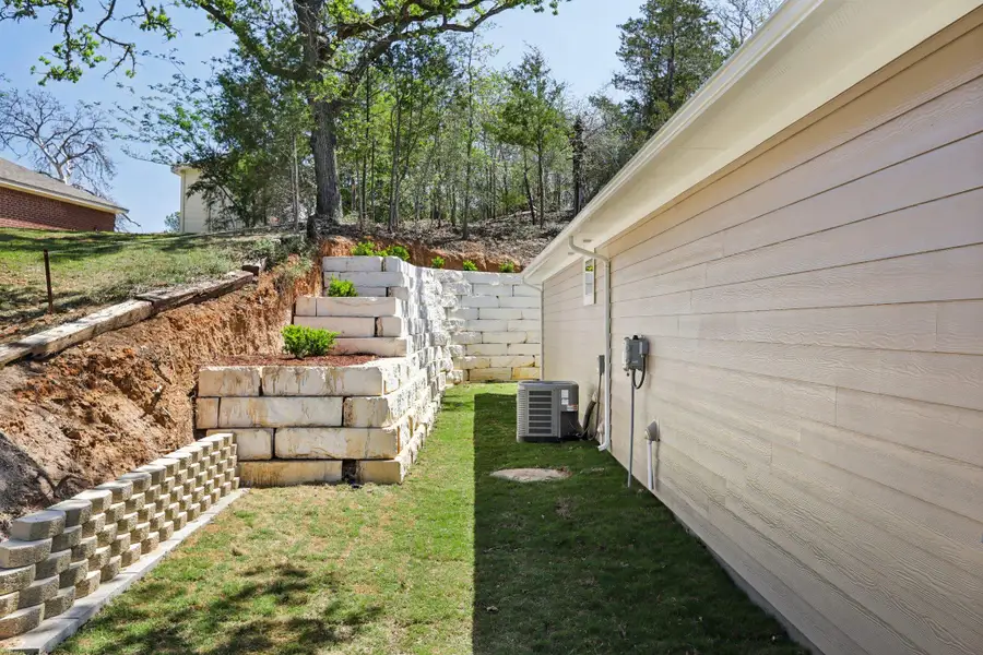 Left view of grassy yard and terraced retention wall