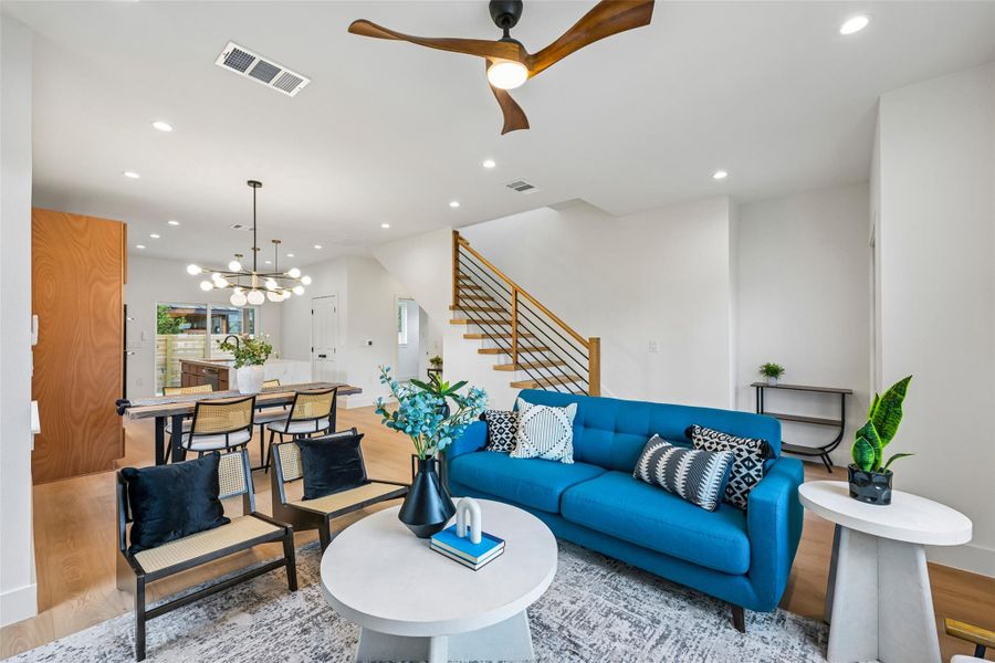 An open-concept layout unites the living and dining areas, illuminated by recessed lighting and a sleek wooden ceiling fan.
