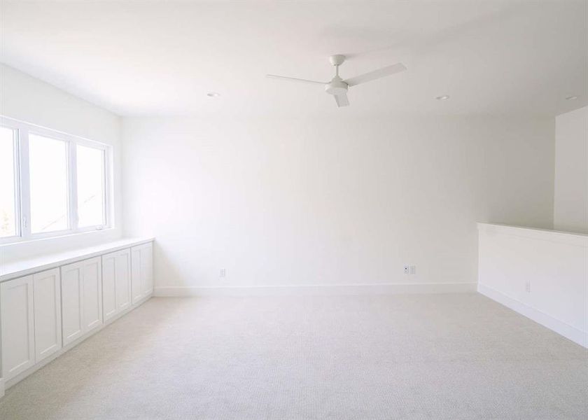 Empty room with light carpet and ceiling fan