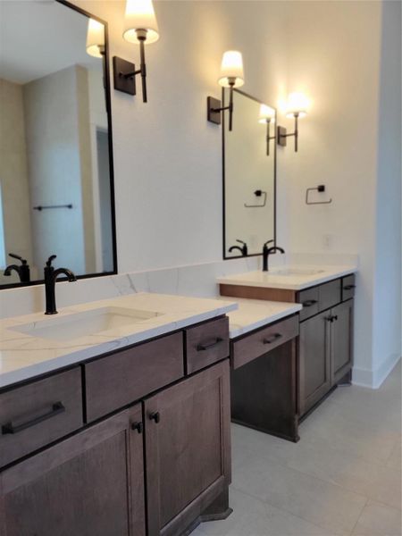 This bathroom features a modern double vanity with quartz countertops, dark wood cabinetry, and stylish lighting fixtures. The design is sleek and inviting, perfect for a contemporary home. This bathroom features a modern double vanity with quartz countertops, dark wood cabinetry, and stylish lighting fixtures. The design is sleek and inviting, perfect for a contemporary home.