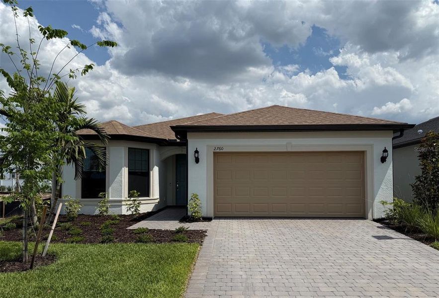 Front exterior of a new home in The Strand at Cedar Grove, North Port, FL, highlighting curb appeal (Image 1).