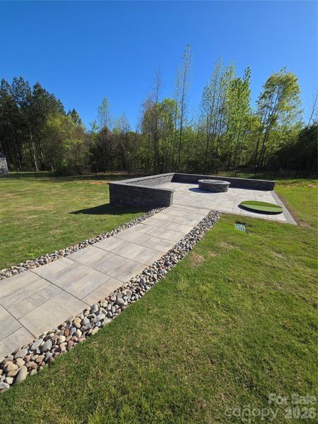 Custom designed paver patio w/gas fire pit surrounded by sitting wall and putting green