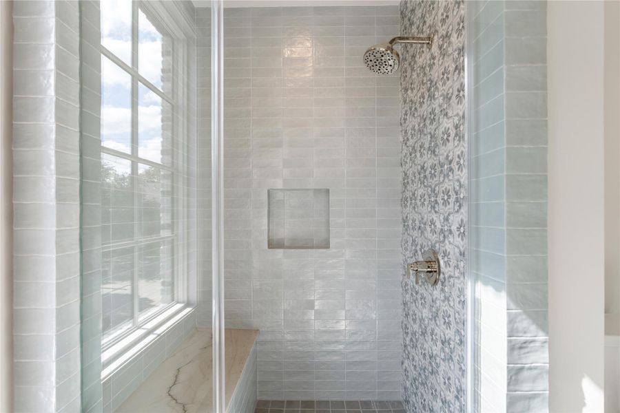 The shower is tucked away at the far end of the space and features a stunning Talia Alta ceramic tile accent wall.