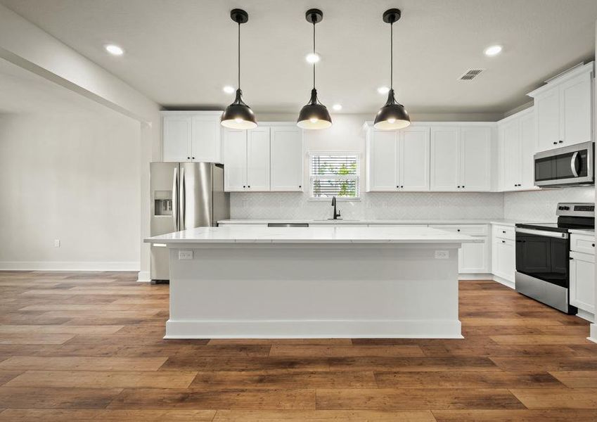 The kitchen has matte black pendants and a modern tile backsplash.