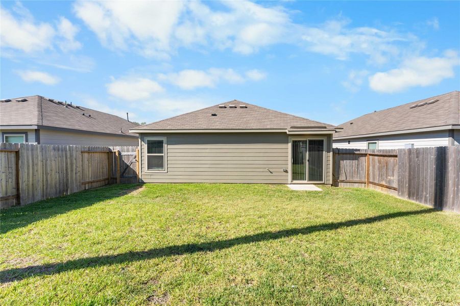 Fenced backyard with rear view of home. Fenced backyard with rear view of home.